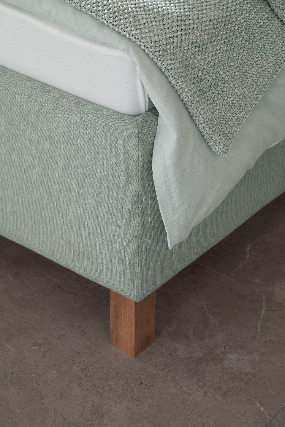 Helles Möbelstück auf dunklen Bodenfliesen.