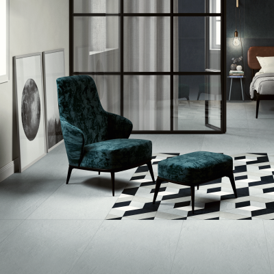 Helle Bodenfliesen in einem stilvollen Wohnzimmer mit Sessel und Glaswand.