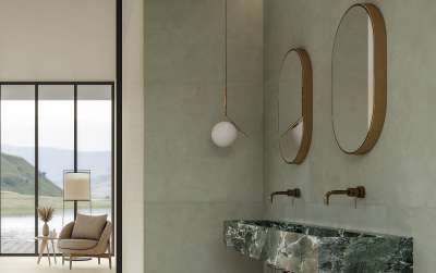 Modernes Bad mit Porcelaingres Wandfliesen in Natursteinoptik, grünen Marmorwaschbecken und ovalen Spiegeln.