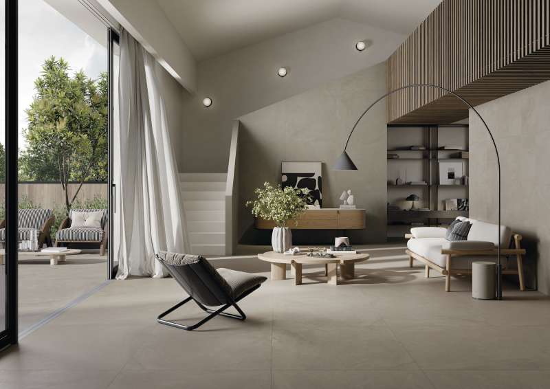 Helle, großformatige Fliesen schaffen einen fließenden Übergang zwischen modernem Wohnzimmer und Terrasse.