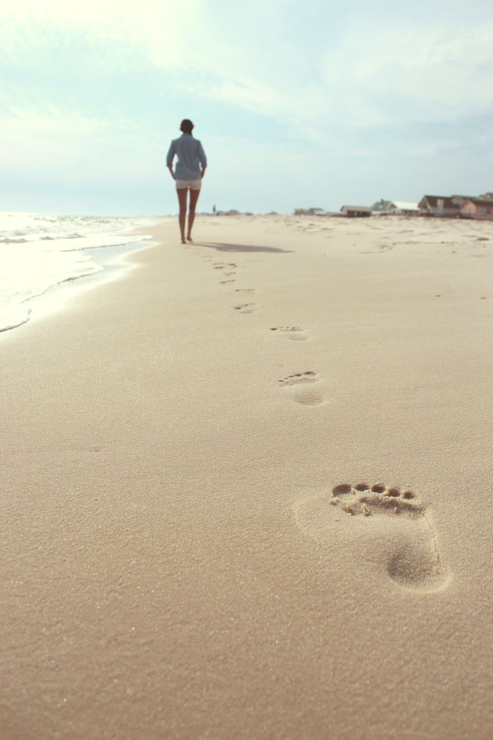 Fußspuren im Sand am Meer. Outdoor-Fliesen-Inspiration.
