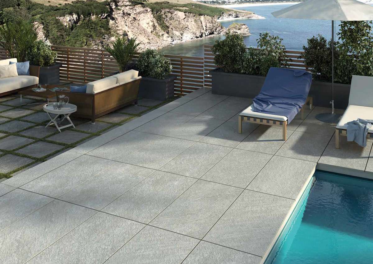 Helle Outdoor-Fliesen auf einer eleganten Terrasse mit Pool und Meerblick.