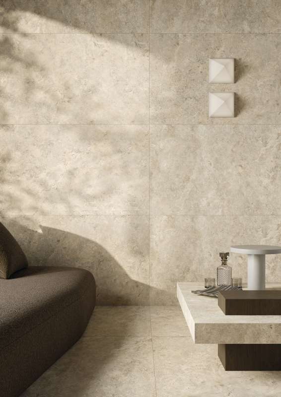 Beige Feinsteinzeugfliesen in Natursteinoptik für Wand und Boden im modernen Wohnzimmer.