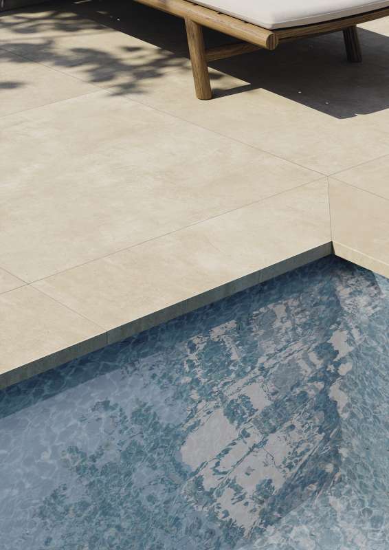 Hochwertige Outdoor-Fliesen am Poolrand mit Sonnenliege.