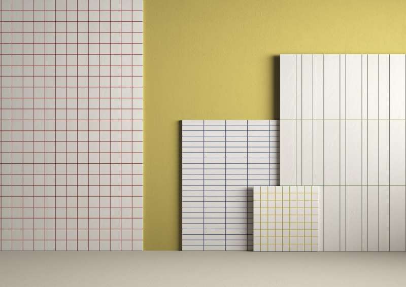 Auswahl an Fliesen mit verschiedenen Mustern: Rotes Gitter, horizontale und vertikale Streifen, vor gelber Wand.