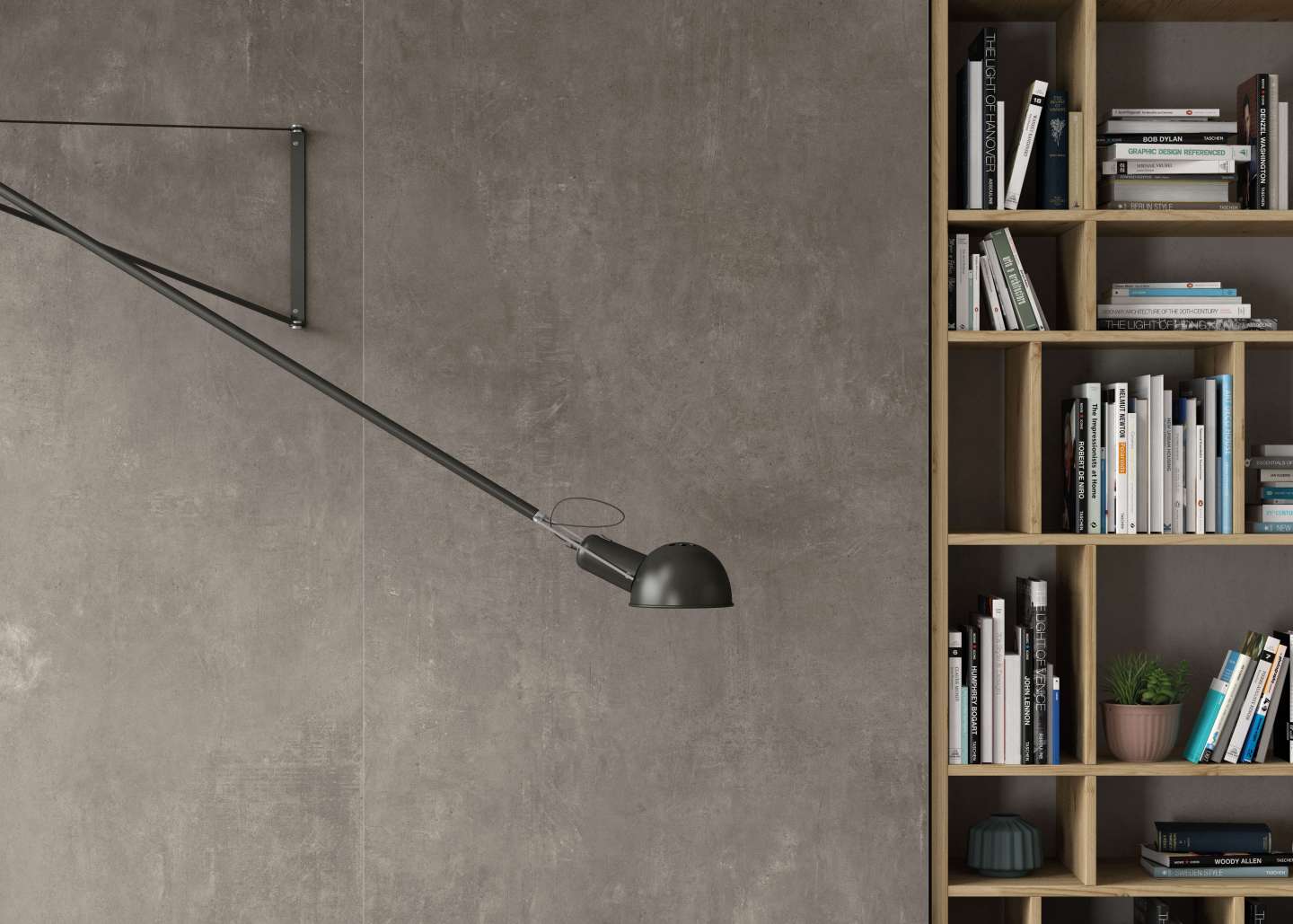 Wandfliesen in dunkler Betonoptik mit Lampe und Bücherregal.