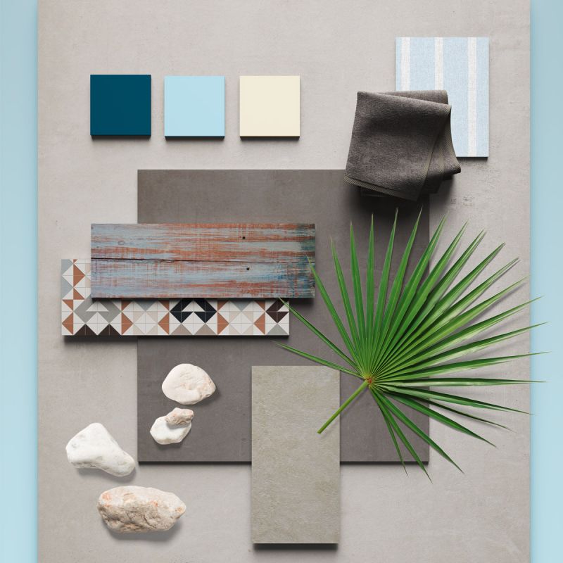 Fliesen-Arrangement in Grau- und Beigetönen mit Pflanze und Deko.