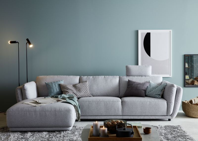 Modernes Wohnzimmer mit grauem Sofa und hellem Fliesenboden.