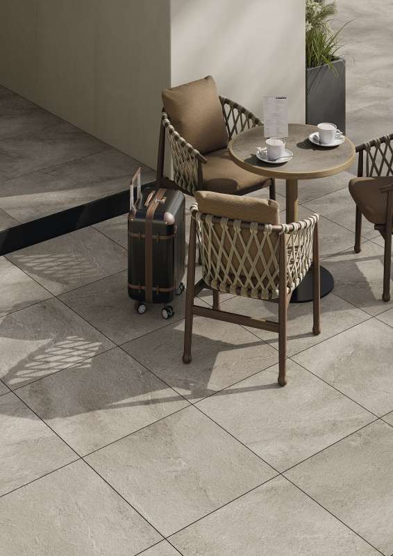 Hochwertige Outdoor-Fliesen in hellem Beige-Grau auf einer stilvollen Terrasse mit Sitzgruppe.