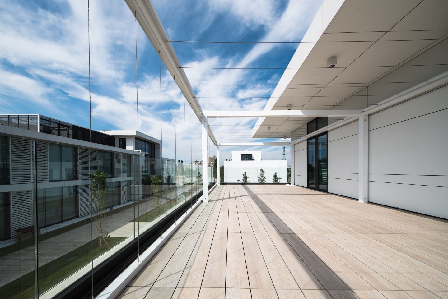 Hochwertige Outdoor-Fliesen in heller Holzoptik auf einer modernen Dachterrasse.