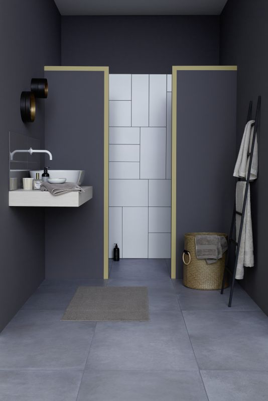 Stilvolles Bad mit grauen Großformat-Bodenfliesen und weißen Wandfliesen im Duschbereich.