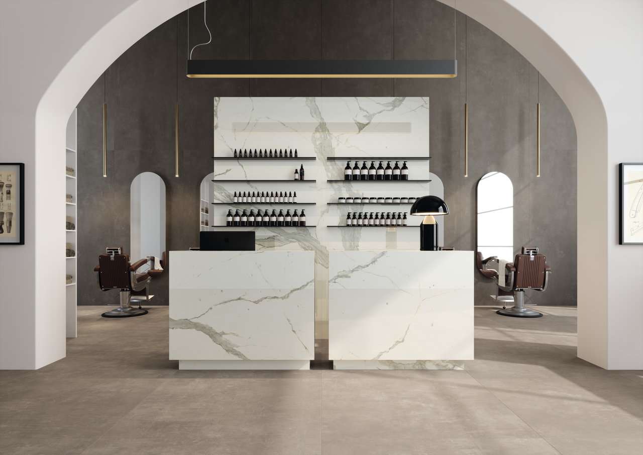 Luxuriöse Porcelaingres Fliesen in Marmoroptik an Rezeption und Wänden, mit passendem Boden.