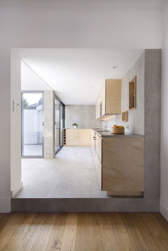 Helle Betonoptik-Fliesen in moderner Küche und auf der Terrasse für nahtlosen Übergang.