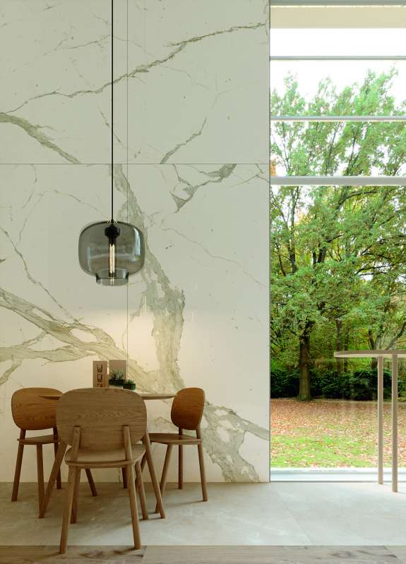 Porcelaingres Wandfliesen in Marmoroptik im Essbereich mit Blick ins Grüne.
