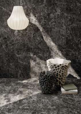 Dunkle Feinsteinzeugfliesen in Marmoroptik an Wand und Boden, stilvoll dekoriert.