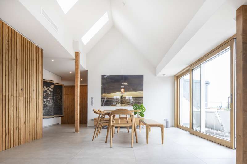 Heller Essbereich mit großformatigem Fliesenboden, Holzakzenten und Zugang zur Terrasse.