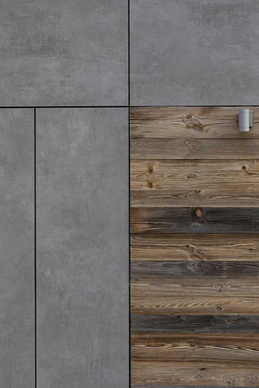 Große graue Betonoptik-Fliesen und rustikale Holzoptik-Paneele.