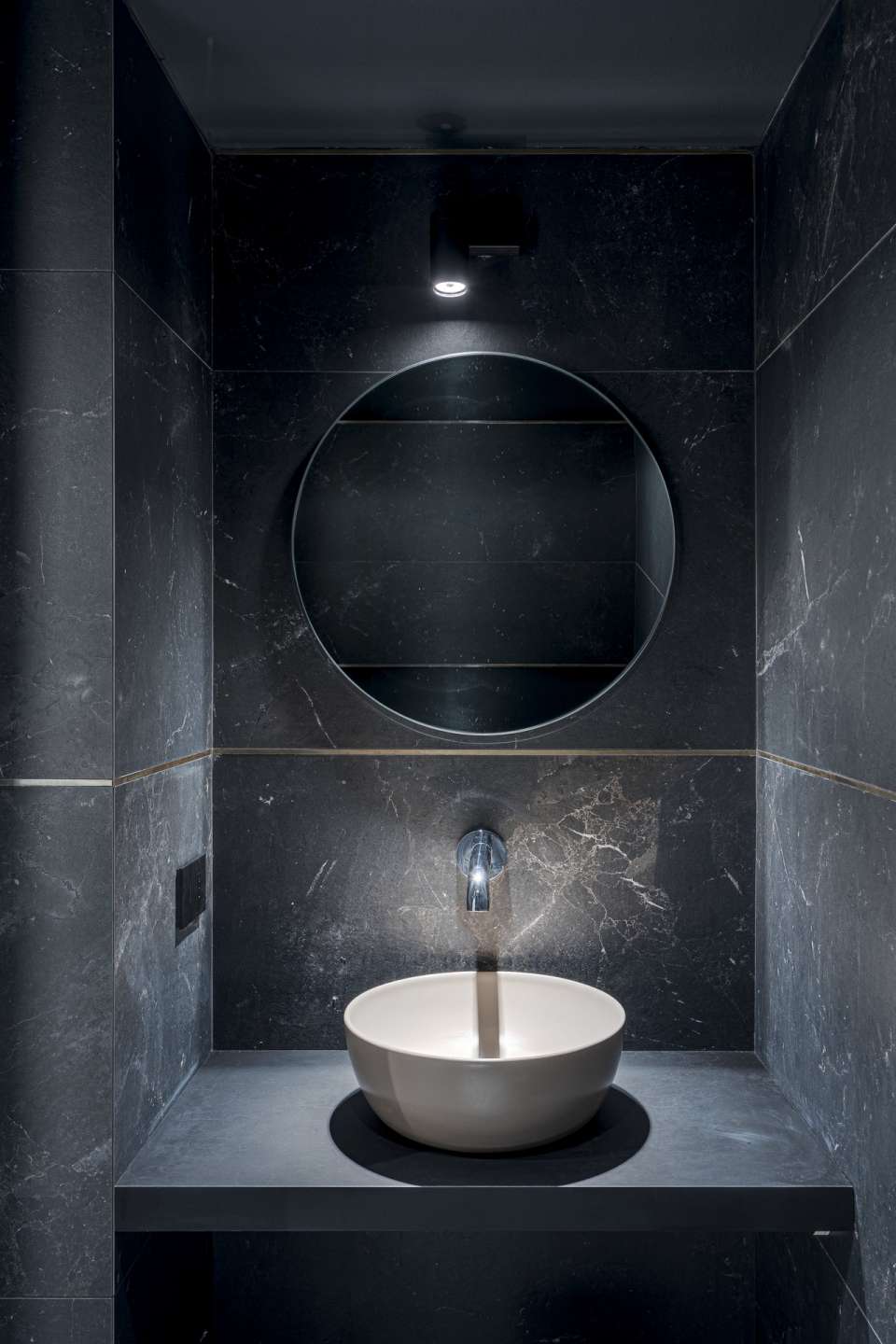 Elegantes Bad mit großformatigen, dunklen Fliesen in Natursteinoptik und modernem Design.