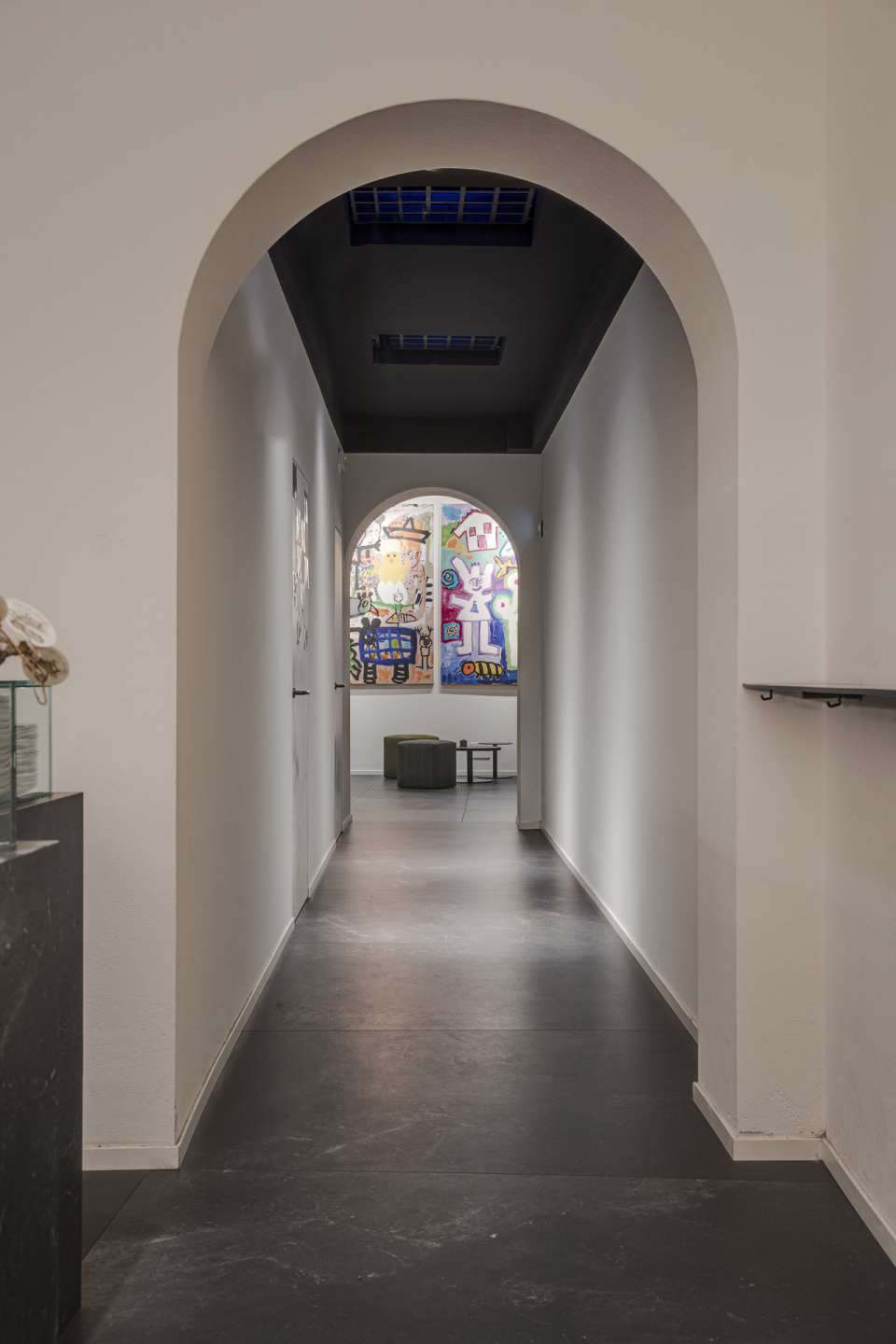 Stilvoller Indoor-Flur mit dunklen Bodenfliesen und hellem Bogen.