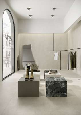 Helle, großformatige Fliesen als Boden- und Wandbelag in modernem Boutique-Ambiente.