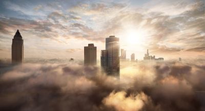 Wolkenkratzer über einer Wolkendecke bei Sonnenaufgang.