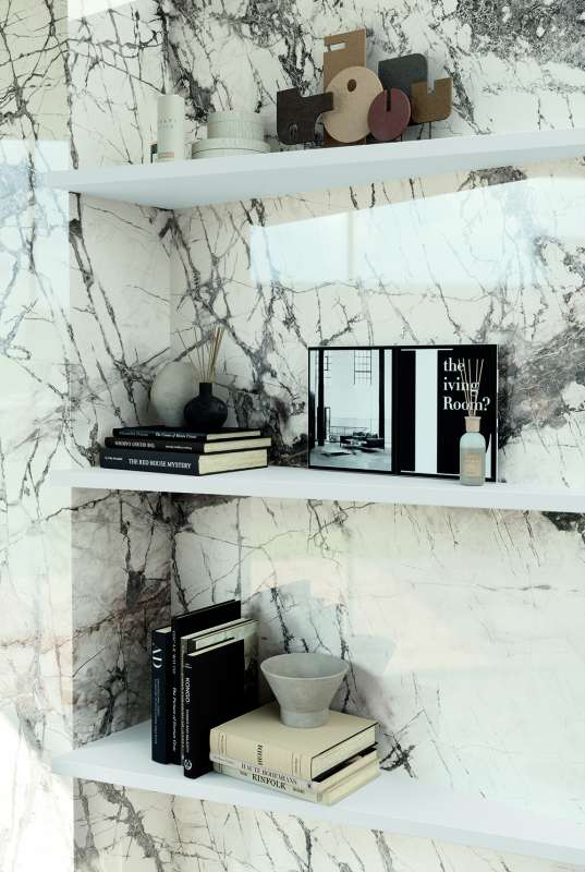 Elegante Wandfliesen in Marmoroptik mit weißen Regalen, dekoriert mit Büchern und Vasen.