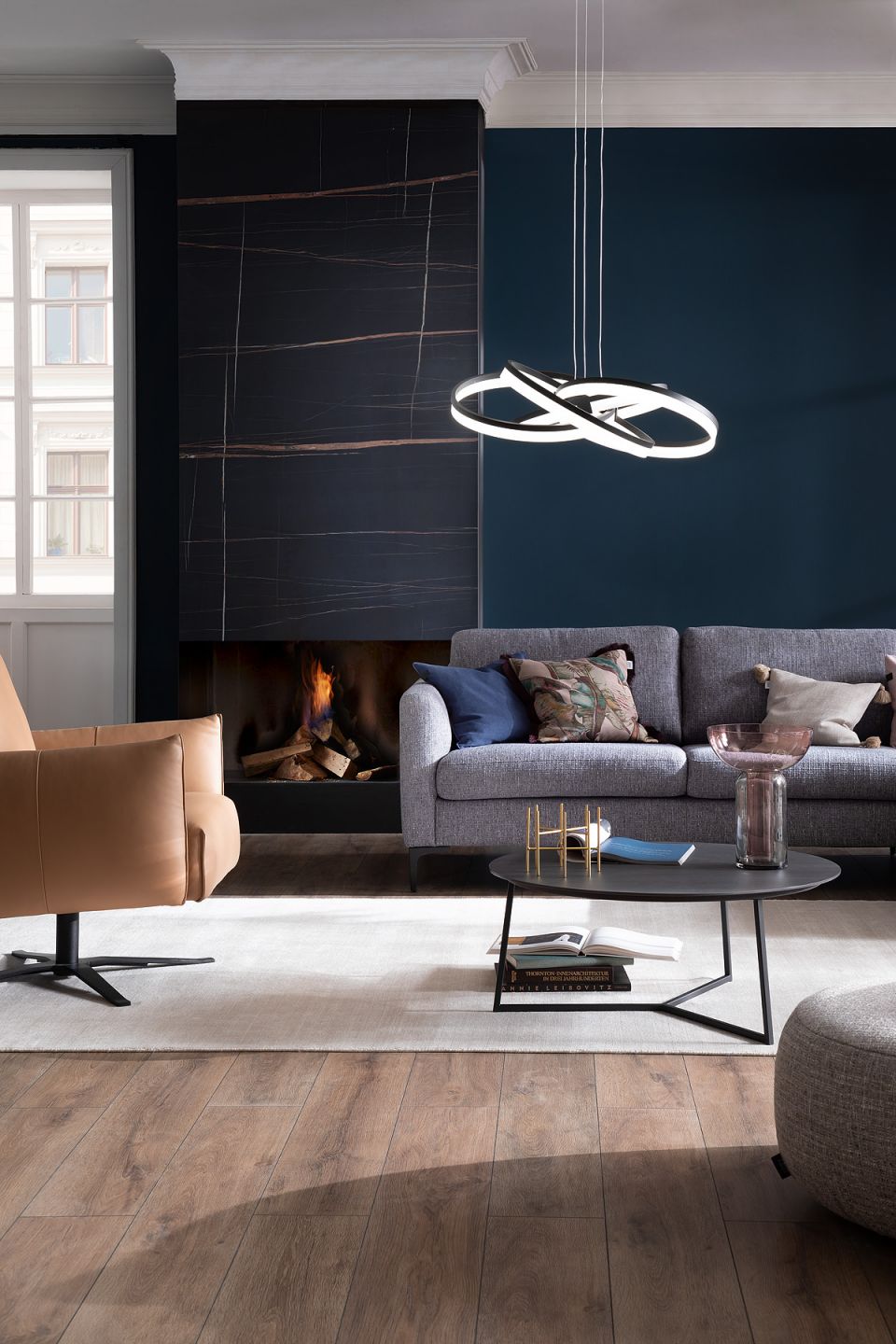 Stilvolles Wohnzimmer mit Porcelaingres Bodenfliesen und dunkler Wandverkleidung.