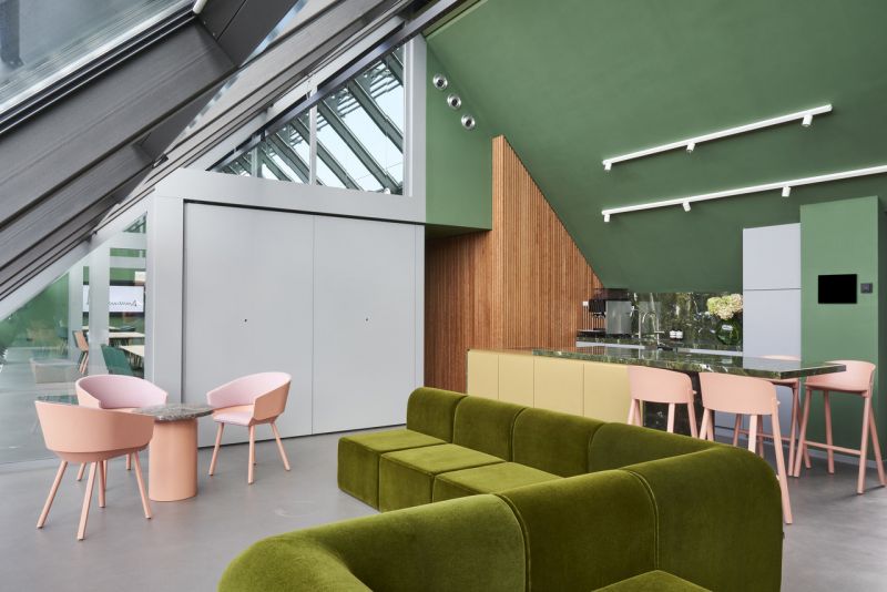 Modernes Loft-Interieur mit grüner Samtcouch und hellem Fliesenboden.