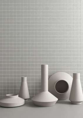 Graue Wandfliesen im Kleinformat mit weißer Fuge, dekoriert mit Vasen.