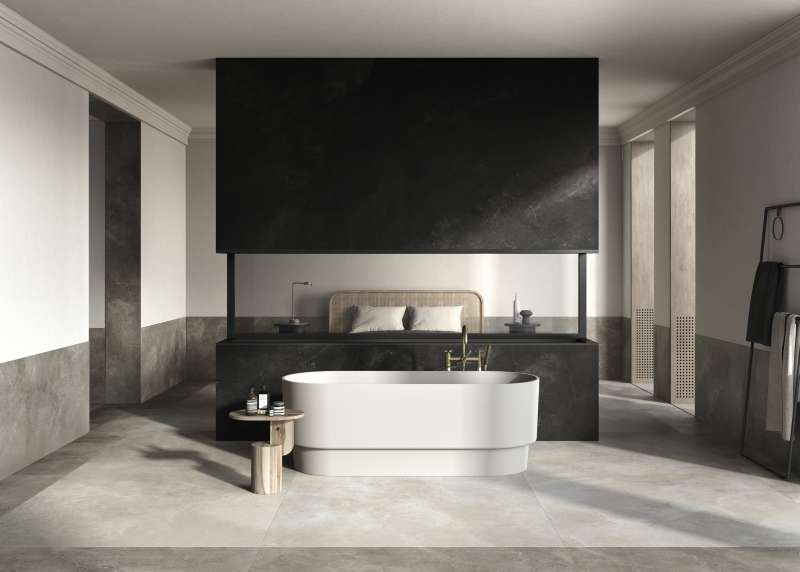 Modernes Badezimmer mit großformatigen Fliesen in Betonoptik und freistehender Badewanne.