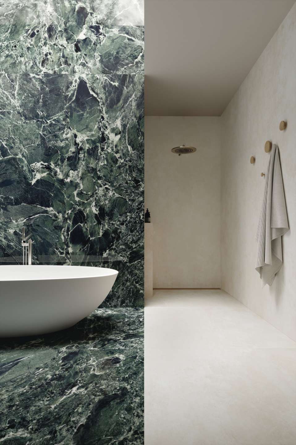 Hochwertige grüne Marmorfliesen im Badezimmer mit freistehender Badewanne und hellem Duschbereich.