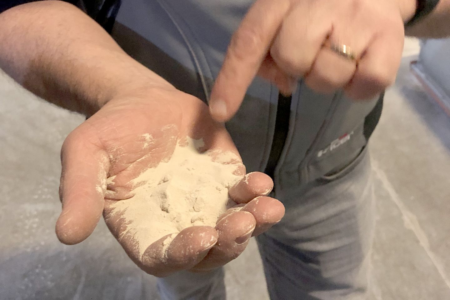 Hand prüft die Qualität von Fliesenmörtel oder Fugenmasse.