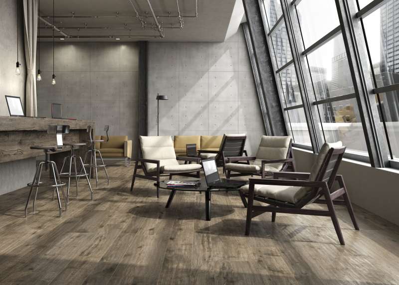 Moderner Loungebereich mit Holzoptik-Bodenfliesen und Betonwand-Design.