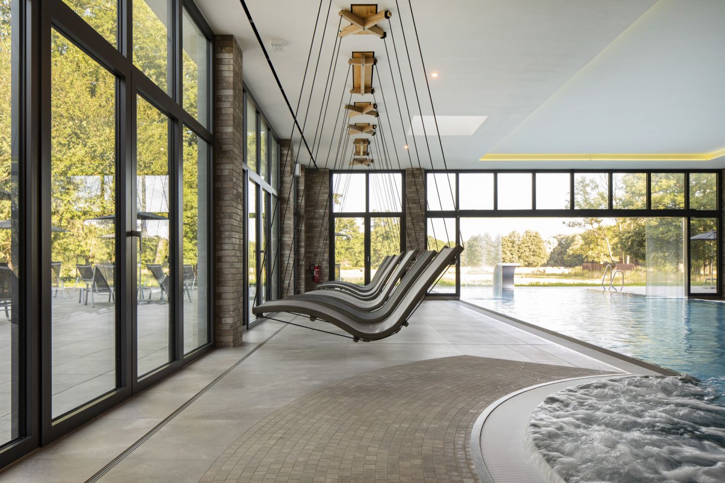 Moderner Wellnessbereich mit großformatigen Fliesen, Pool, Whirlpool und Panoramafenstern.