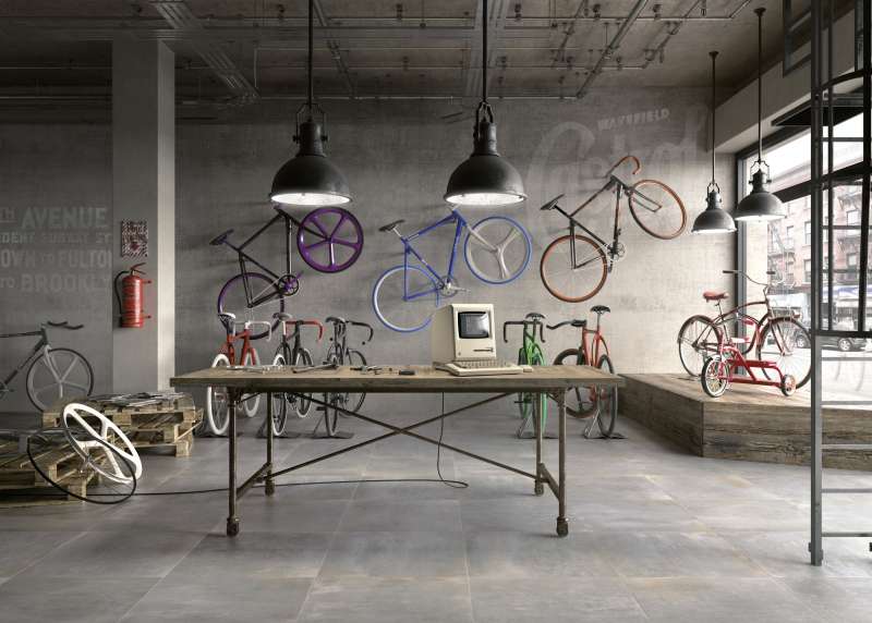 Hochwertige graue Betonoptik-Fliesen in urbanem Loft mit Fahrrädern.