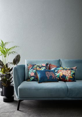 Modernes Wohnzimmer mit blauem Sofa und elegantem Fliesenboden.