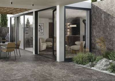 Hochwertige anthrazitfarbene Fliesen verbinden Terrasse und modernen Wohnraum, auch als Wandverkleidung.