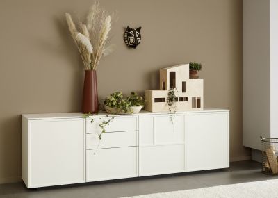 Heller Wohnraum mit modernem Sideboard und hellem Fliesenboden.