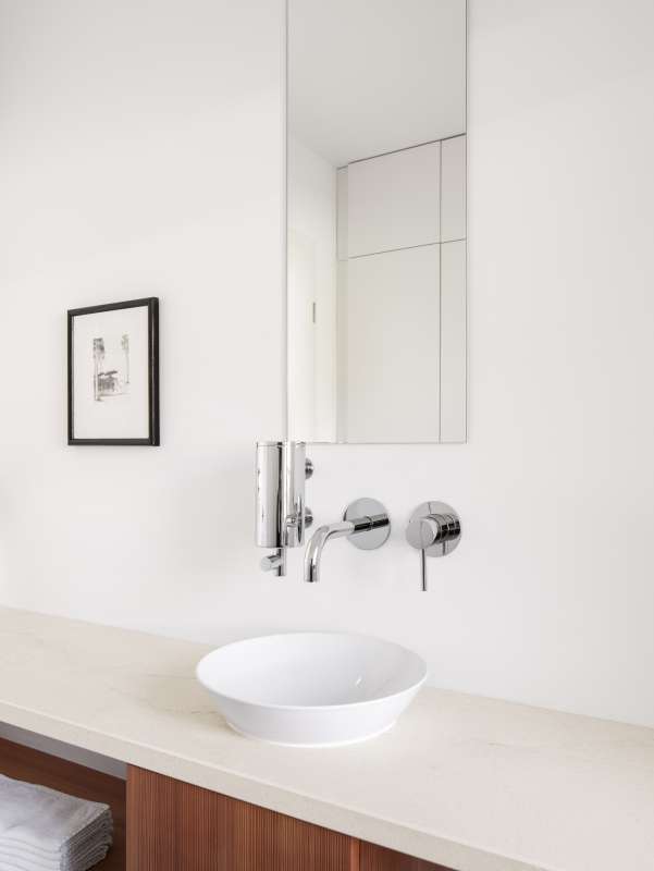 Modernes Bad mit großformatigen Fliesen an Wand und Waschtischplatte.