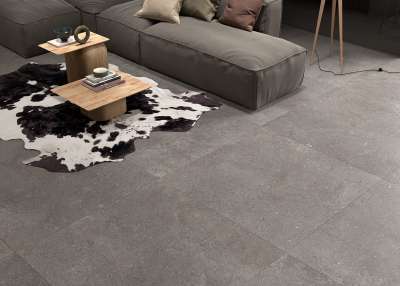 Großformatige, dunkelgraue Bodenfliesen in einem modernen Wohnzimmer.