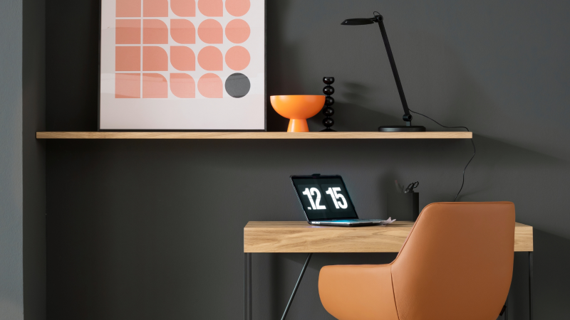 Modernes Home-Office mit dunkler Wand, Holzschreibtisch und braunem Stuhl, ideal für hochwertige Indoor-Fliesen.