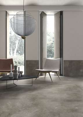 Stylischer Wohnraum mit grauen Feinsteinzeug-Bodenfliesen in Betonoptik.