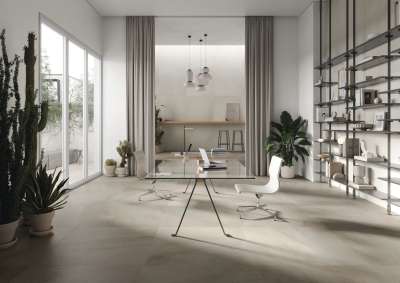 Geräumiges, helles Büro mit modernen Fliesen, Glas-Schreibtisch und Pflanzen.