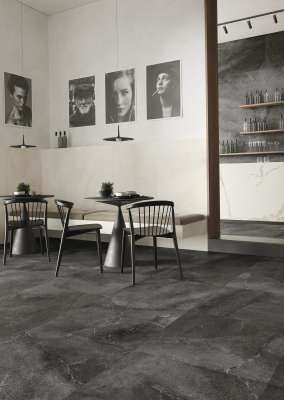 Dunkle, großformatige Bodenfliesen in Steinoptik in einem modernen Café.