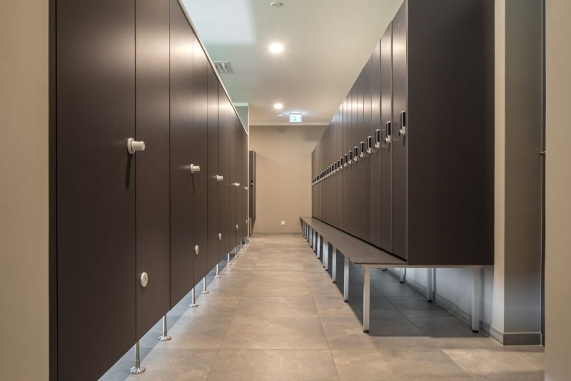 Moderner Umkleidebereich mit hellgrauen Bodenfliesen und dunklen Spinden.