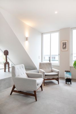 Hochwertiger hellgrauer Fliesenboden in modernem Wohnraum mit Sesseln.