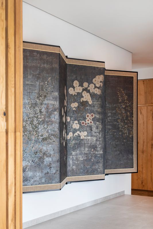 Moderner Raum mit floralem Paravent und hellem Fliesenboden.