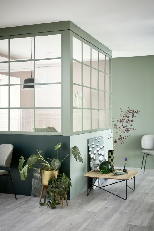 Modernes Interieur mit hellen Bodenfliesen, Sofa und eleganter Trennwand.