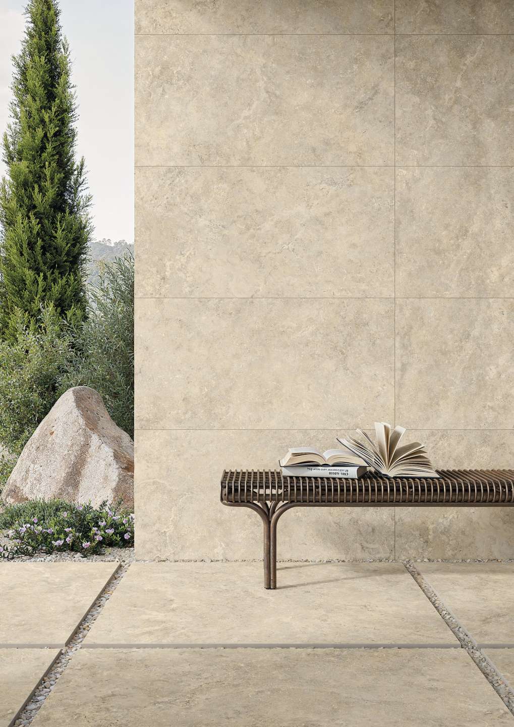 Beige Outdoor-Fliesen in Natursteinoptik für Wand und Boden, mit Gartenbank.