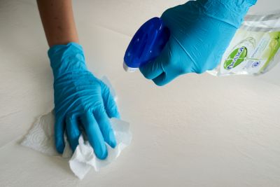 Einfache Reinigung von hellen Fliesen mit Handschuhen und Reinigungsmittel.